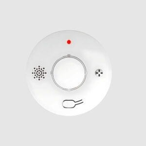 Détecteur de fumée connecté avec alarme rond de couleur blanche avec un voyant rouge en haut sur fond gris clair.